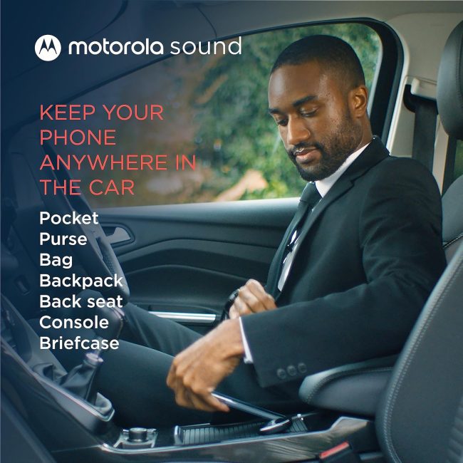 Man in car secures seatbelt demonstrating ease with the Motorola MA1, providing adaptable car audio placement