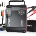 UTRAI portable jump starter with a digital display and air compressor, including clamps, nozzles, hose, and carry case