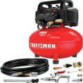 Red Craftsman air compressor with accessories for car detailing,   including coiled hose and various nozzles,   labeled 'Made in the USA with global materials'