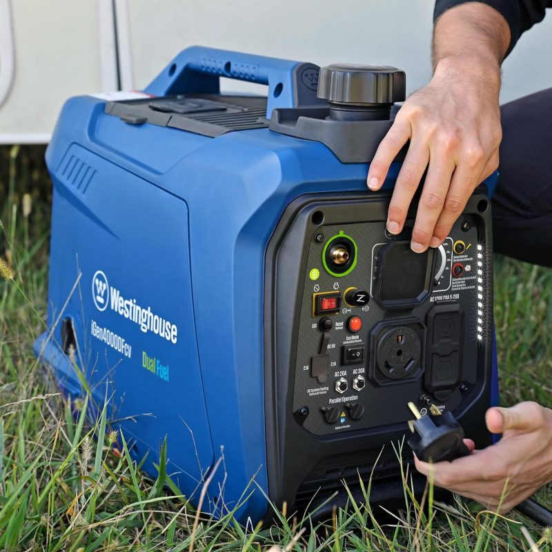 Person operating a Westinghouse iGen4500DFc generator on grass, showing control panel and outlets