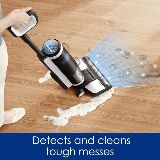 Vacuum cleaner with digital display cleaning tough messes on a wooden floor, utilizing technology to detect dirt