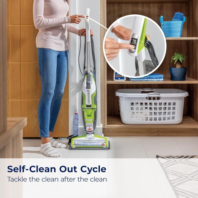 Person using Bissell cleaning machine on tiled floor next to shelves