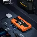 AstroAI portable jump starter connected to multiple devices, displaying various output settings on its LCD screen