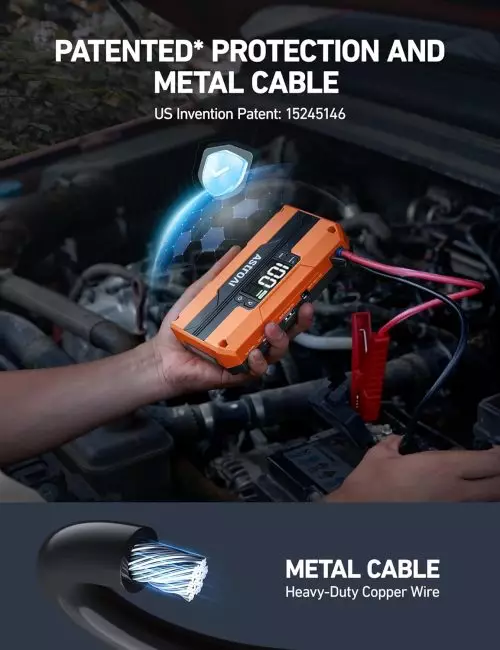 Orange battery jump starter with digital display showing 12.0V in car engine compartment