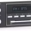 A vintage-style car stereo displaying FM 87.5 with number preset buttons,   volume/mode,   and tune/band knobs