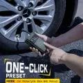 Person using a digital tire inflator to check car tire pressure with display showing pressure reading