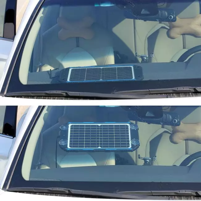 Car interior view from windshield showing a solar panel on the dashboard and a bone-shaped cushion on the seat.